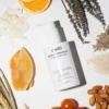 Flat lay photography of cadó Leave-in Conditioner surrounded by natural ingredients like orange, lavender, and almonds to highlight the organic formula.